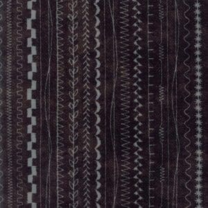 Dark fabric with various zigzag and linear stitch patterns.