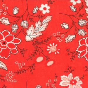 Red fabric with white and black floral patterns and leaves.