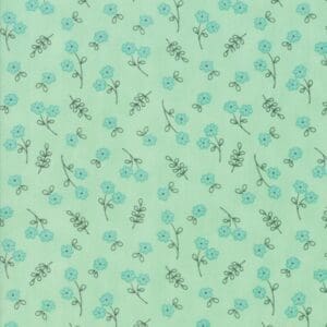 Light green fabric with a delicate blue and brown floral pattern.