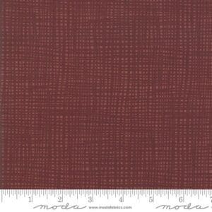 Textured brown fabric with subtle grid pattern and measurement scale.