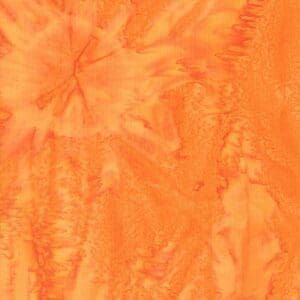 Close-up of orange tie-dye fabric with starburst patterns.