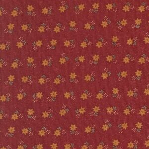 Red fabric with a repeating floral pattern in yellow and orange hues.