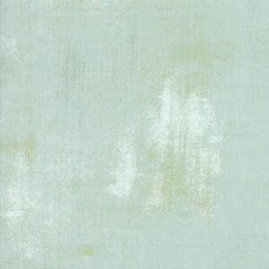 Abstract textured background in pale green and white tones.