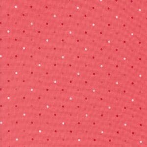 Close-up of pink fabric with small white dots pattern.
