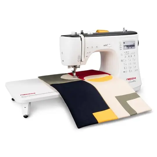 White sewing machine stitching colorful geometric fabric