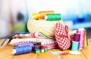 picture of sewing supplies including thread, bobbins, and fabric.