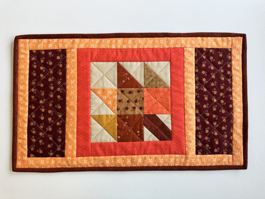 Patchwork quilt with geometric patterns and colors.