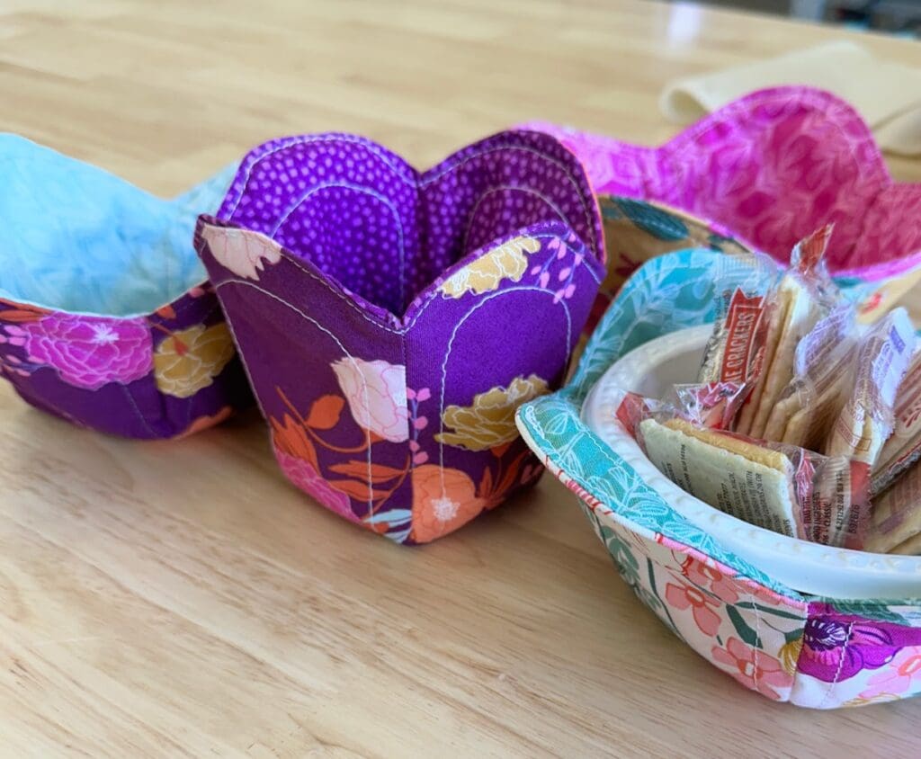 Colorful fabric bowls on wooden table.
