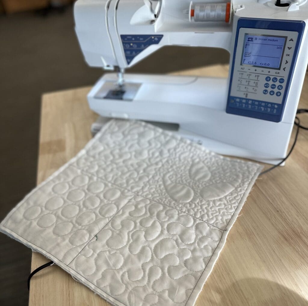 Sewing machine with quilted fabric piece.