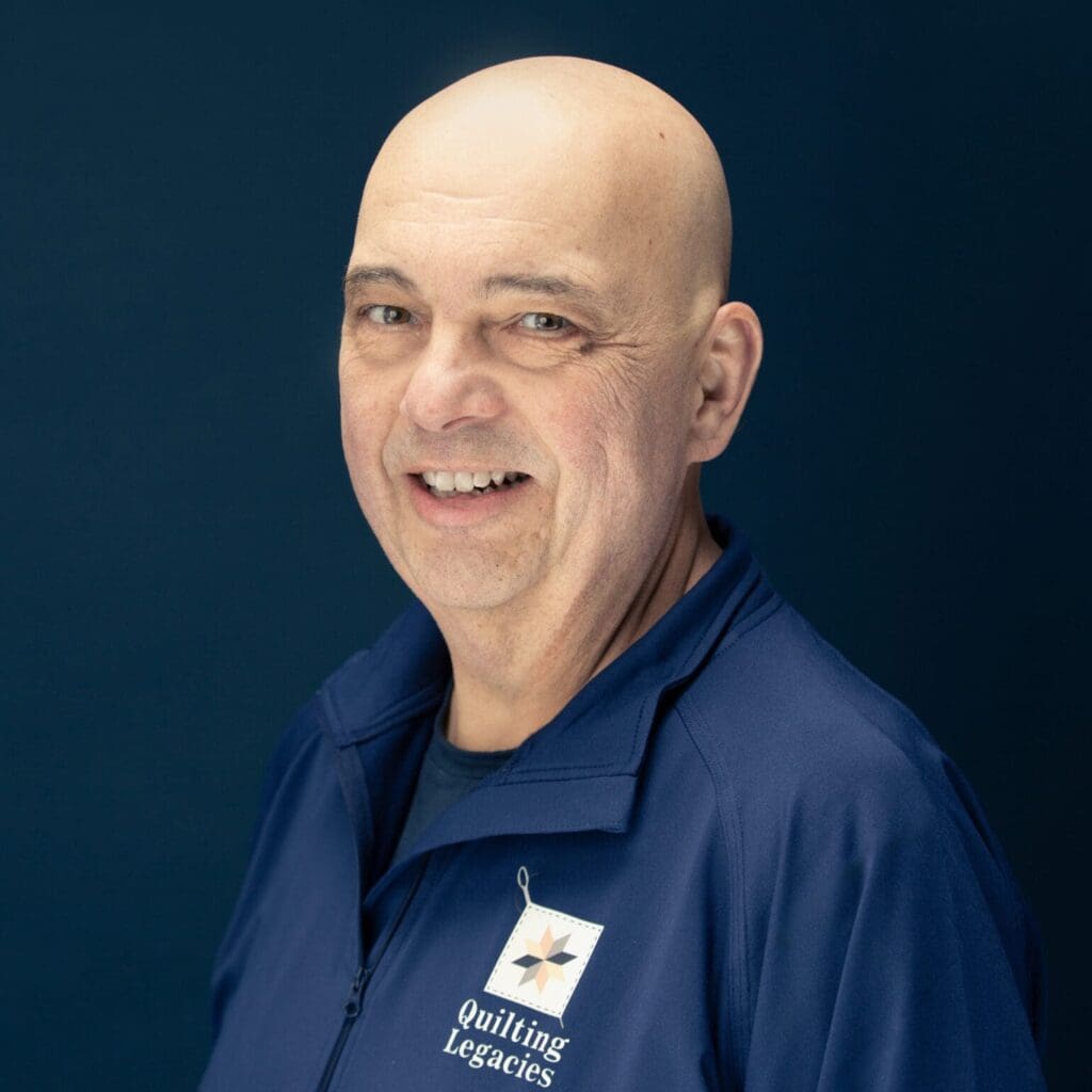 Smiling man in a blue jacket.