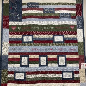 Holiday patchwork quilt with embroidered phrases