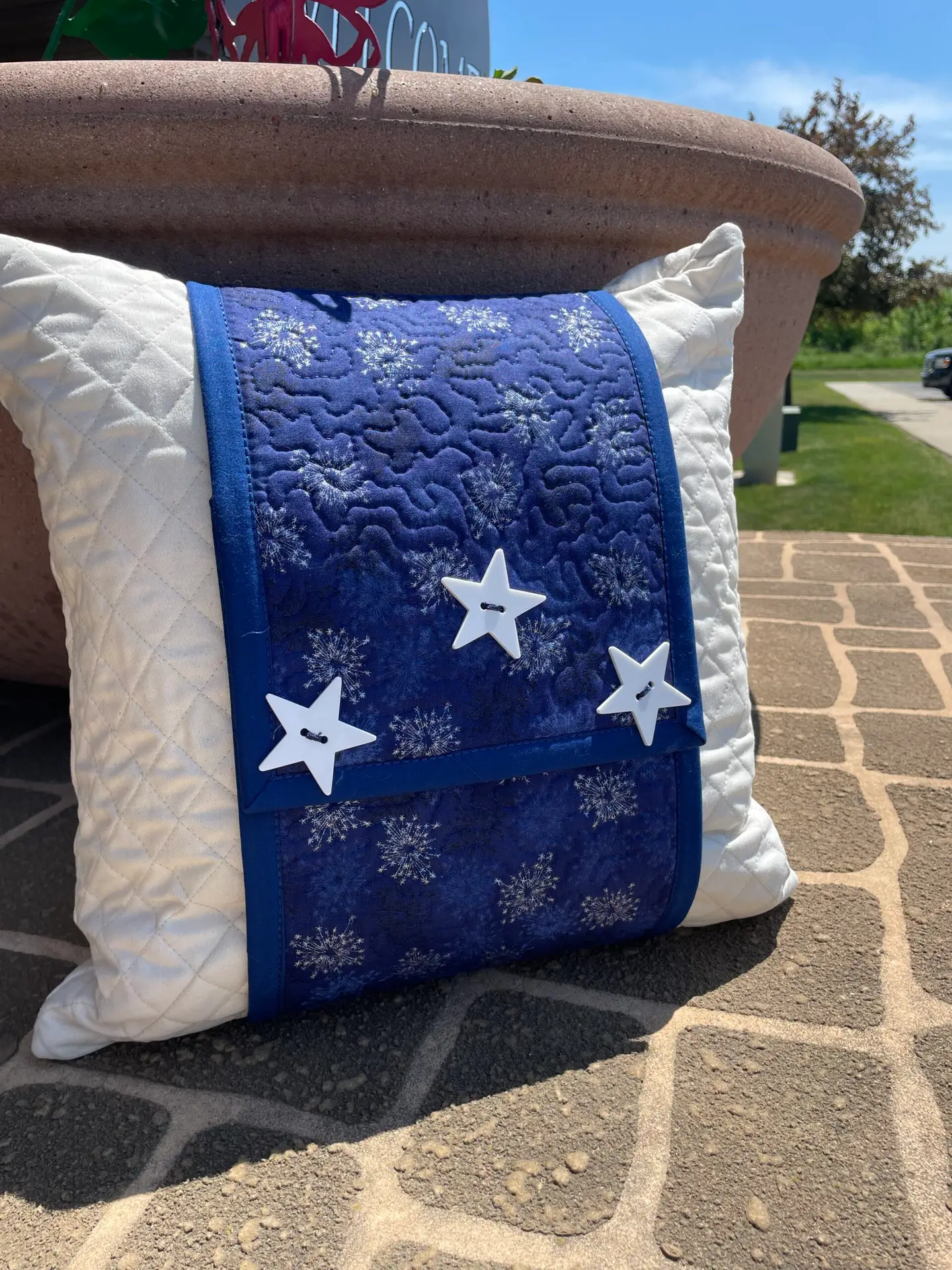 Quilted white pillow with blue star panel