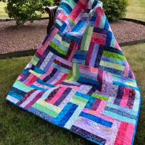 Colorful patchwork quilt draped over chair