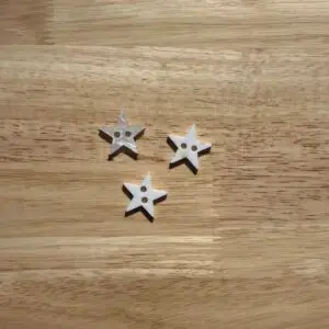 Three white star-shaped buttons on wood