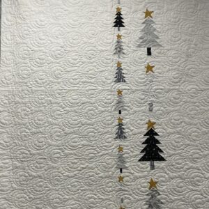 White quilt with vertical trees and stars