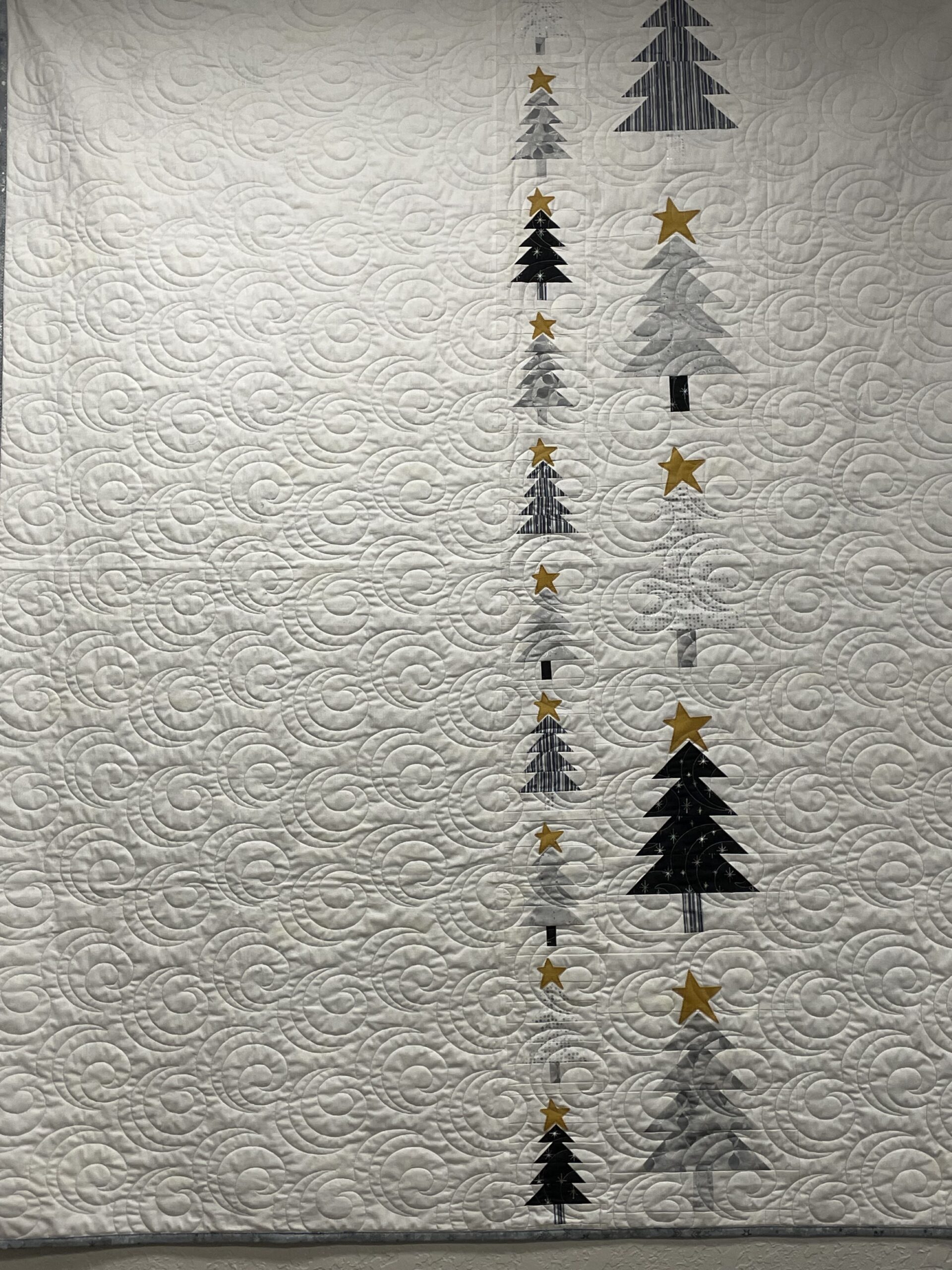 White quilt with vertical trees and stars